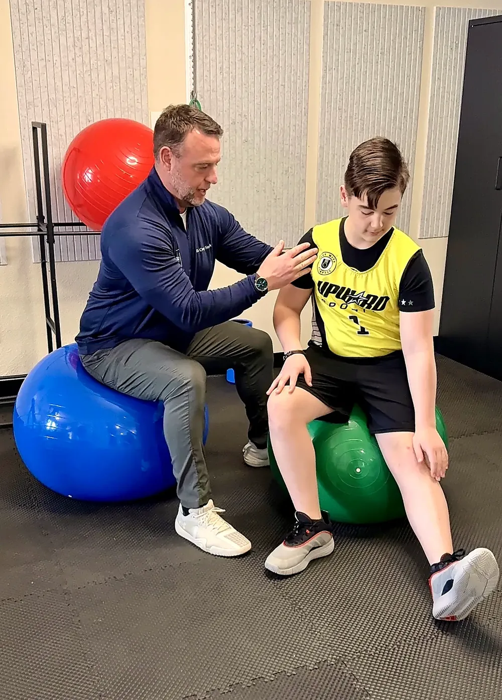 Dr. Corey Strunk guiding a young athlete through a movement assessment in his Keller office